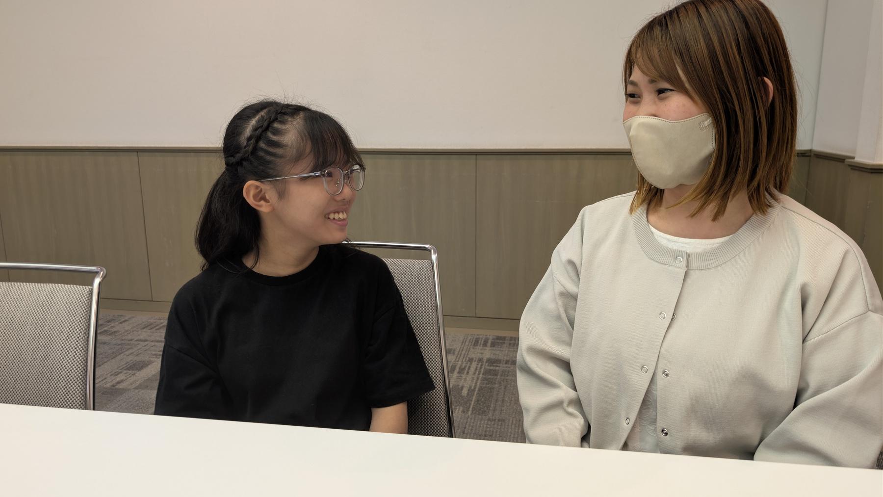 大会会場で保護者と並び、笑顔で取材に答える生徒